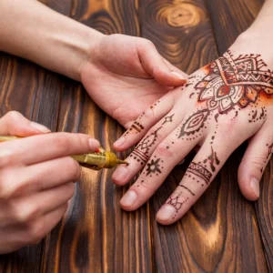 artist-making-mehndi-womans-hand